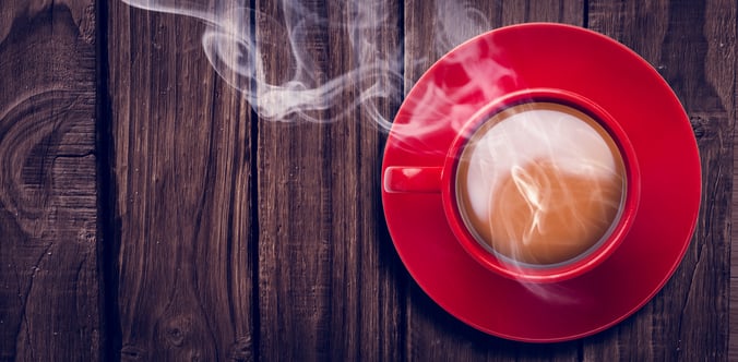 Overhead view of red tea cup against wooden table